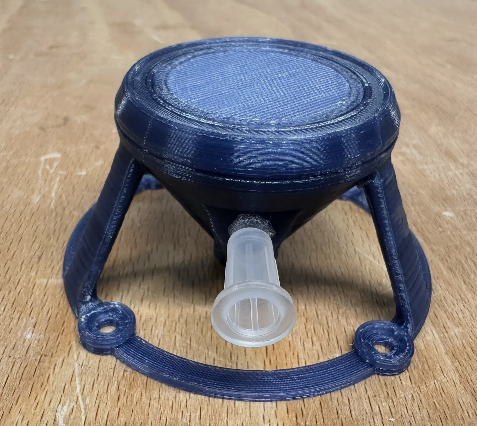 The base with the strand-mesh filter support seated, syringe port visible.