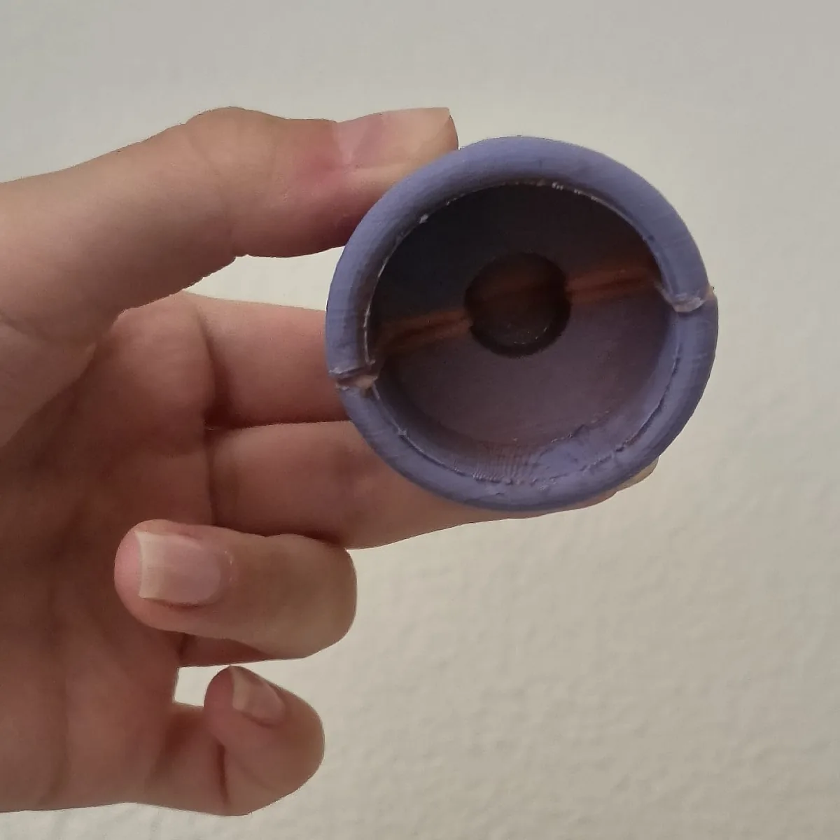 Looking into the opening of the Duckbill prototype: a round dark opening crossed by a thin orange line.