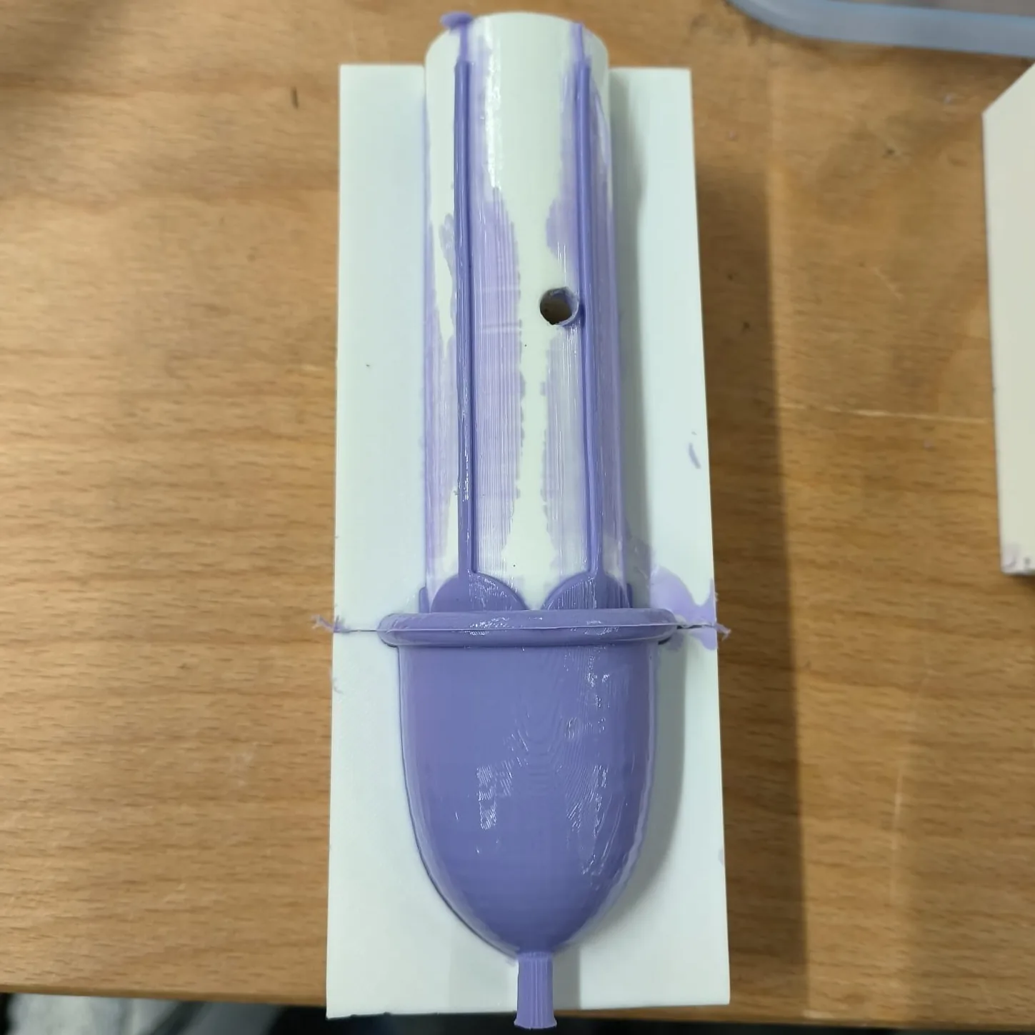 The Flower Low cup being demoulded: the petals and two strings cast straight along the printed mould core.